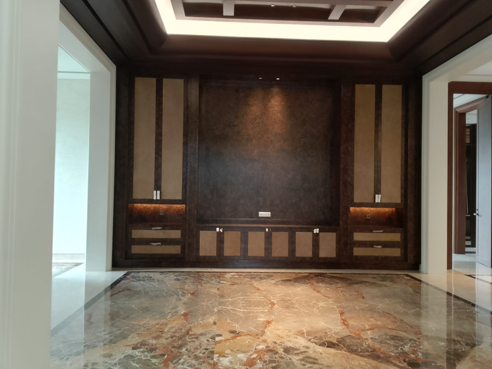 Backdrop TV cokelat tua dengan panel kayu HPL veneer